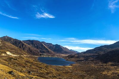 Scenic view of lake and mountains against blue sky