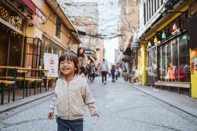 Portrait of young woman standing in city