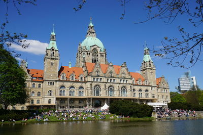 New town hall by lake against blue sky