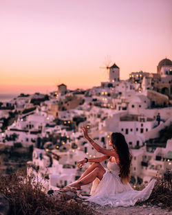 High angle view of woman with umbrella against sky during sunset