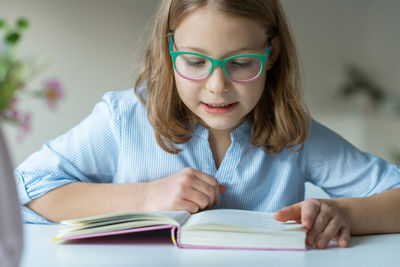 Close-up of girl reading book