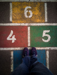 Low section of man standing on tiled floor