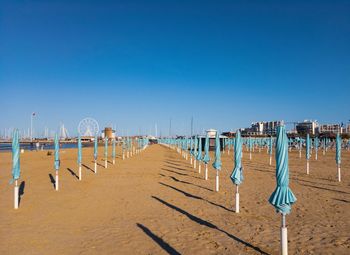 Sun umbrellas closed on the beach on the adriatic coast of italy. rimini