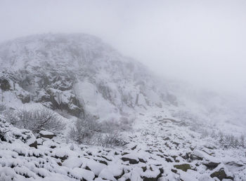 Snow covered land against sky