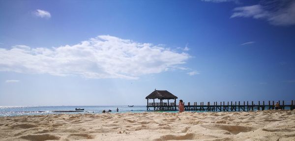 Lifeguard hut on beach against blue sky