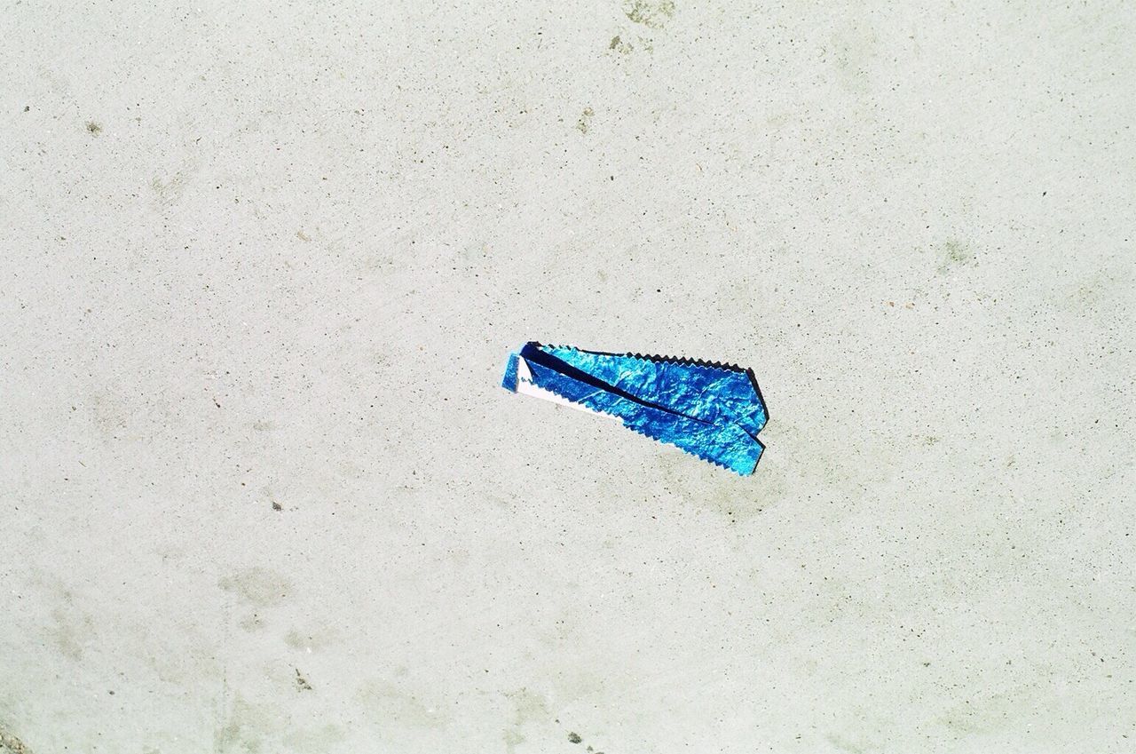 blue, still life, high angle view, wall - building feature, single object, close-up, copy space, no people, wall, textured, absence, white color, abandoned, day, paint, outdoors, simplicity, plastic, metal, white