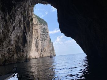 Scenic view of rock formation in sea against sky