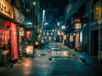 Illuminated street in city at night