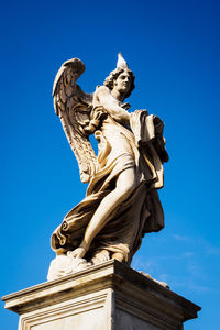 Low angle view of statue against blue sky