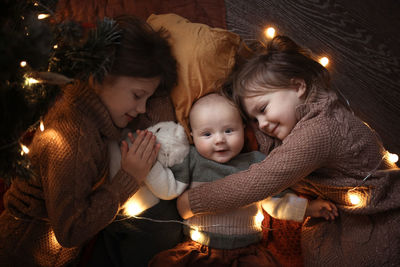 Several children and a cat in a dark cozy interior, the concept of childhood and pets