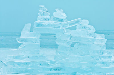 Stack of ice on frozen sea against blue sky