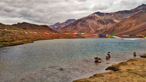 Scenic view of lake by mountains against sky