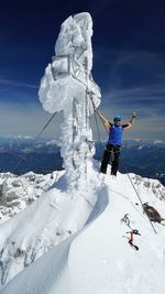 Person standing on snow covered mountain against sky