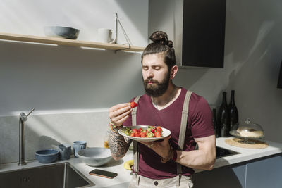 Young man standing on table at home