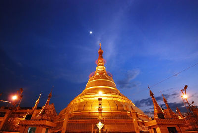 Low angle view of illuminated temple against blue sky