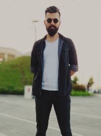 Portrait of young man wearing sunglasses standing outdoors