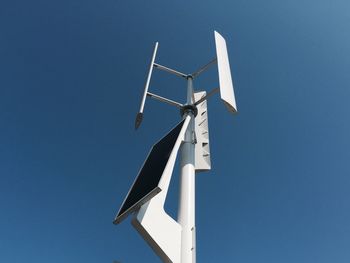 Low angle view of windmill against clear blue sky