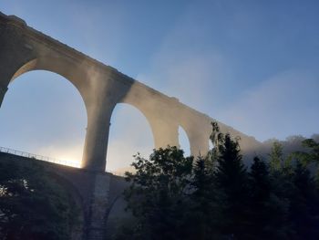Low angle view of arch bridge against sky