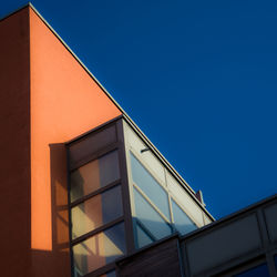 Low angle view of modern building against blue sky