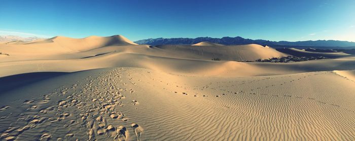 Scenic view of desert against clear blue sky