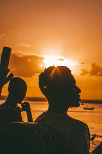 Friends hanging out at the beach during sunset