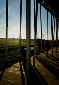 Silhouette people standing by railing against sky