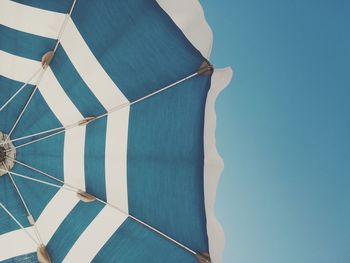 Low angle view of blue umbrella against clear sky