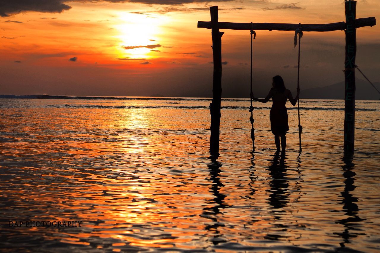 sunset, water, sea, silhouette, reflection, orange color, lifestyles, leisure activity, sun, scenics, sky, horizon over water, beauty in nature, tranquility, beach, standing, tranquil scene, men