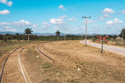 View of railroad tracks on field against sky