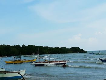 Boats moored on sea against sky