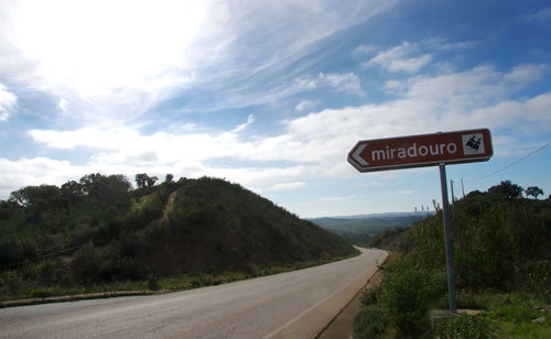 Road sign against sky