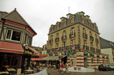 Cars on street amidst buildings in city against sky