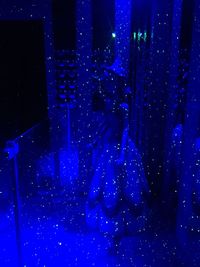 Midsection of man with umbrella at night