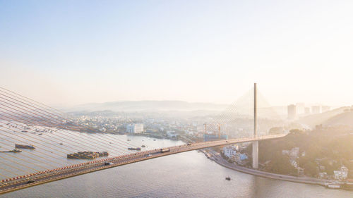 Bridge over river in city against clear sky