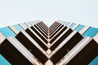 Directly below shot of office building against clear sky