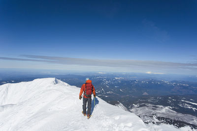 A man climbs to the summit of mt. hood in oregon.