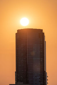 Modern building against sky during sunset