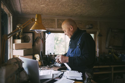 Gay man with paper document working in garage