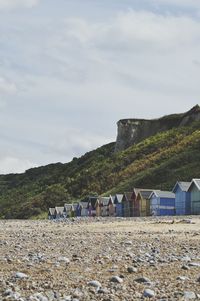 Beach houses on field against sky