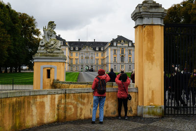 People at augustusburg and falkenlust palaces against sky