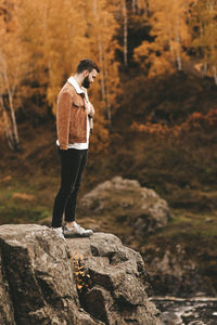 Full length of young woman standing on rock