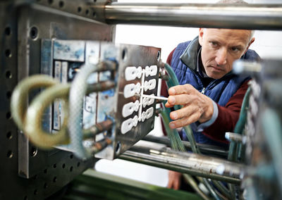 Man examining machine at factory