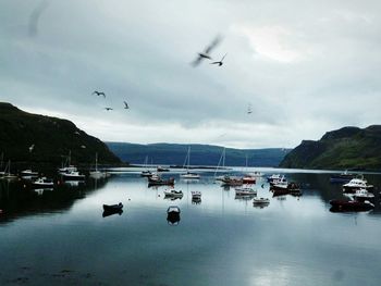 Boat in sea against cloudy sky