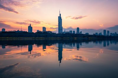 Reflection of buildings in city during sunset