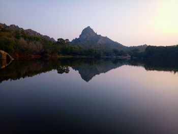 Scenic view of lake by mountains against clear sky