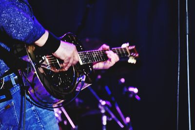 Close-up of man playing guitar