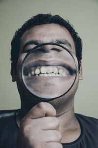 Close-up portrait of man with magnifying glass