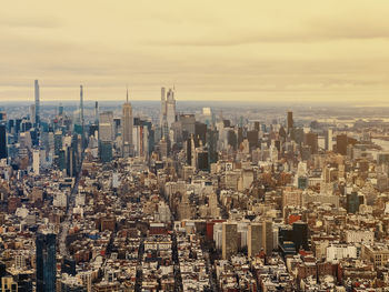 Aerial view of cityscape against sky during sunset in manhattan