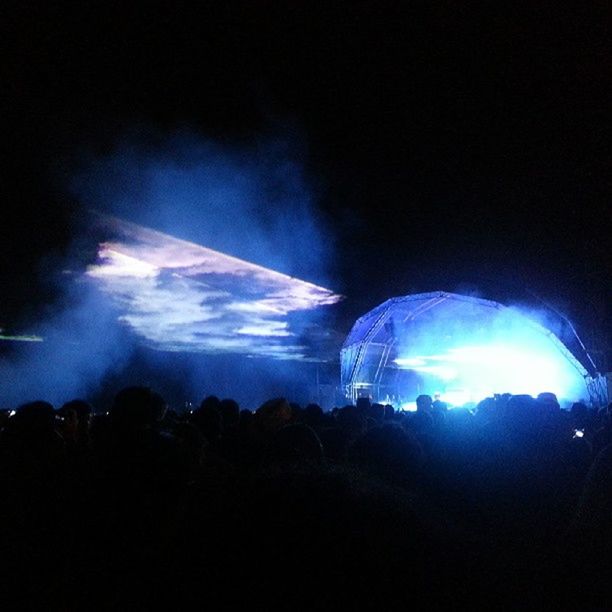 night, illuminated, arts culture and entertainment, sky, large group of people, silhouette, low angle view, enjoyment, light - natural phenomenon, blue, leisure activity, crowd, fun, excitement, celebration, event, copy space, motion, dark