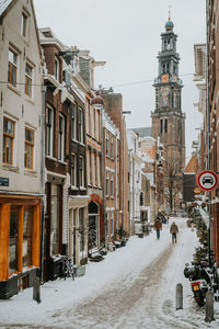 Street amidst buildings in city during winter